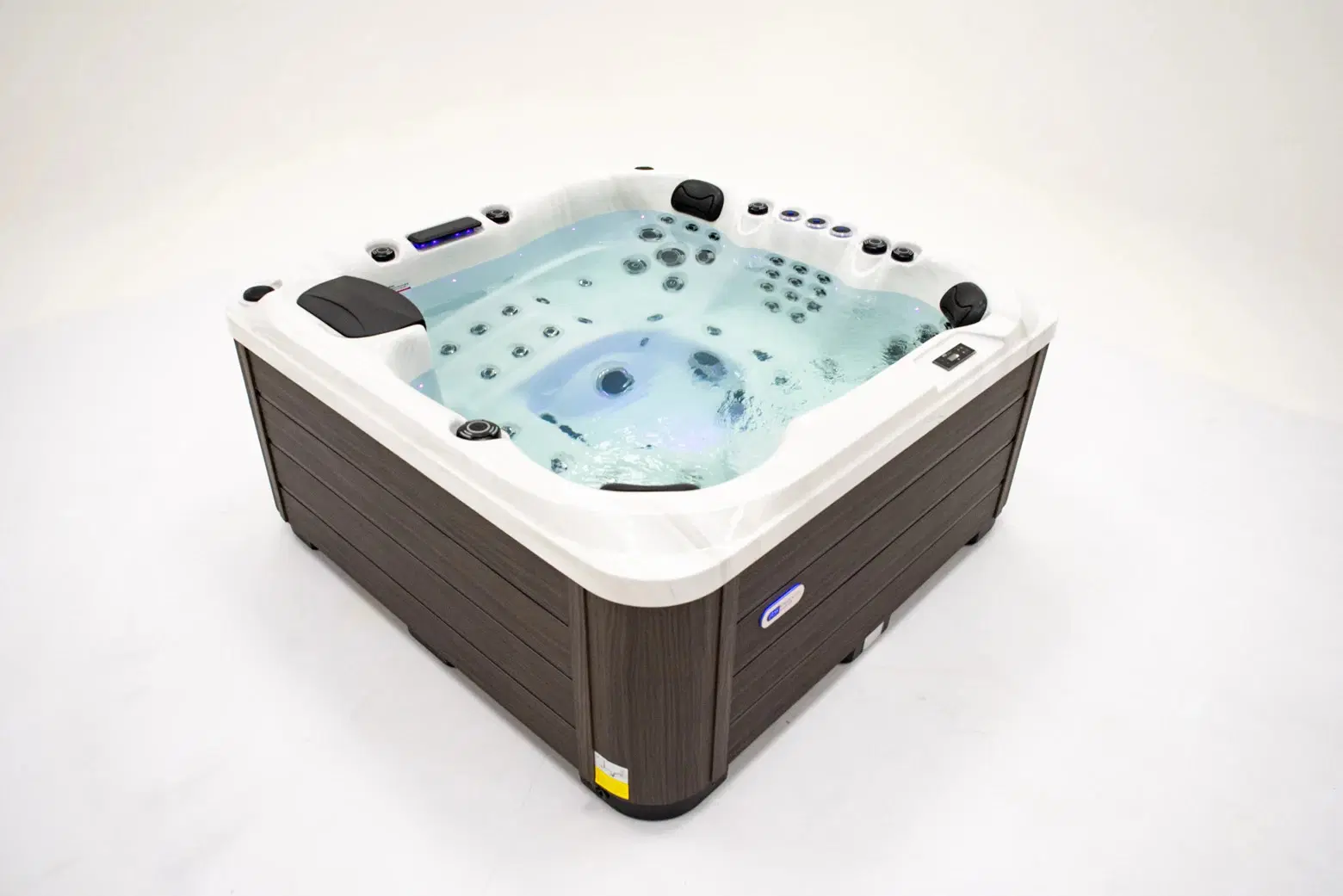 White hot tub with multiple jets and dark wood paneling, filled with water.