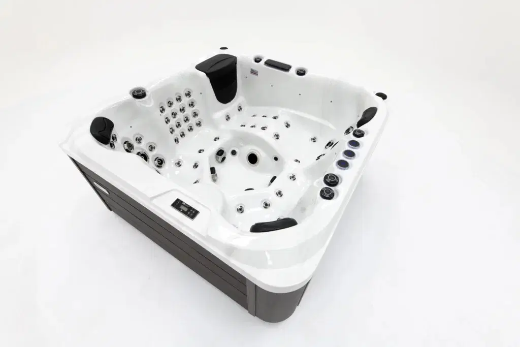 White rectangular hot tub with multiple chrome jets, black headrests, and a control panel on the side.
