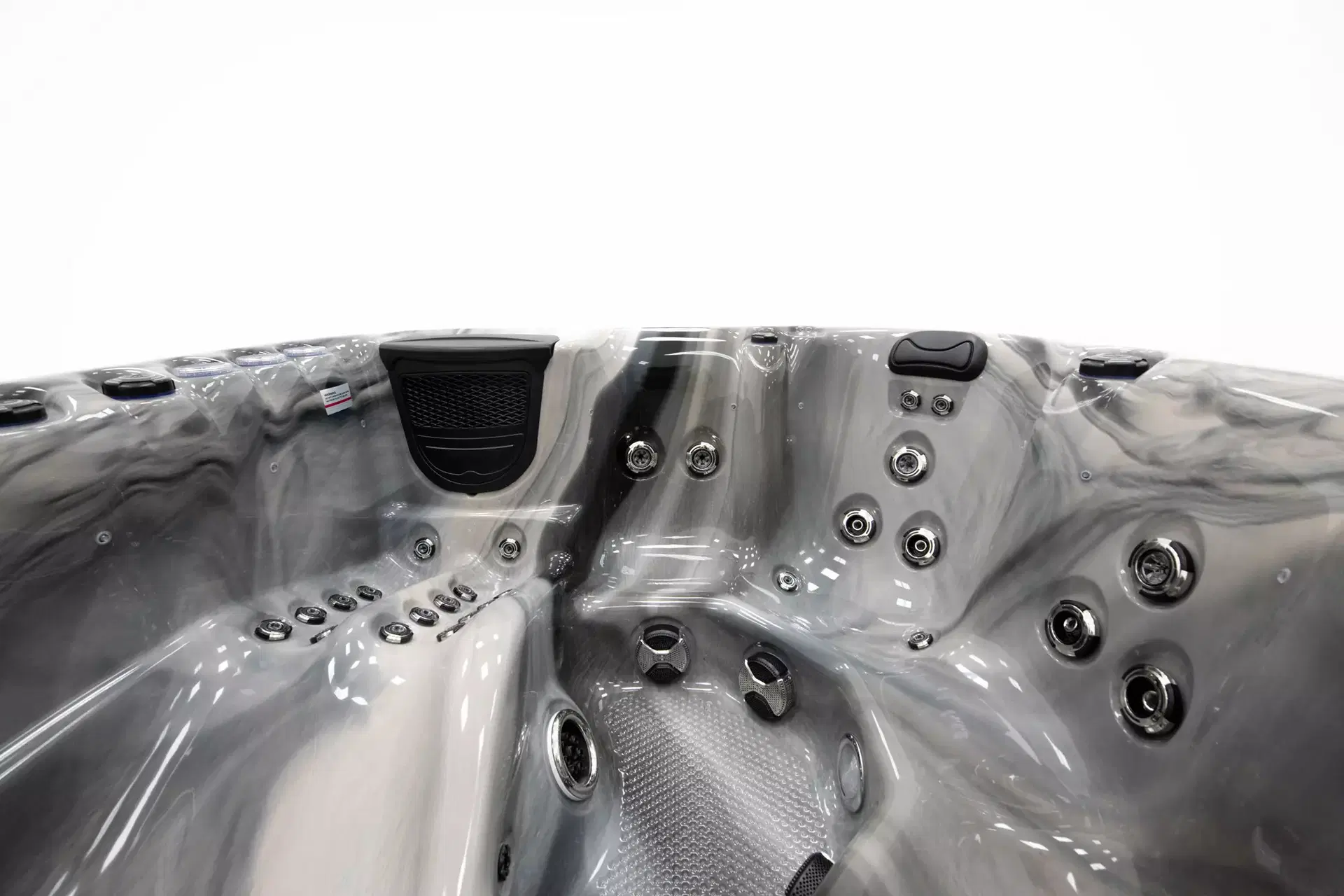 Luxurious gray hot tub interior with multiple chrome jets, built-in seating, and control panel visible on the side.